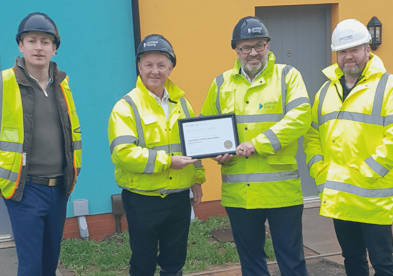 group of four construction workers holding premier guarantee award