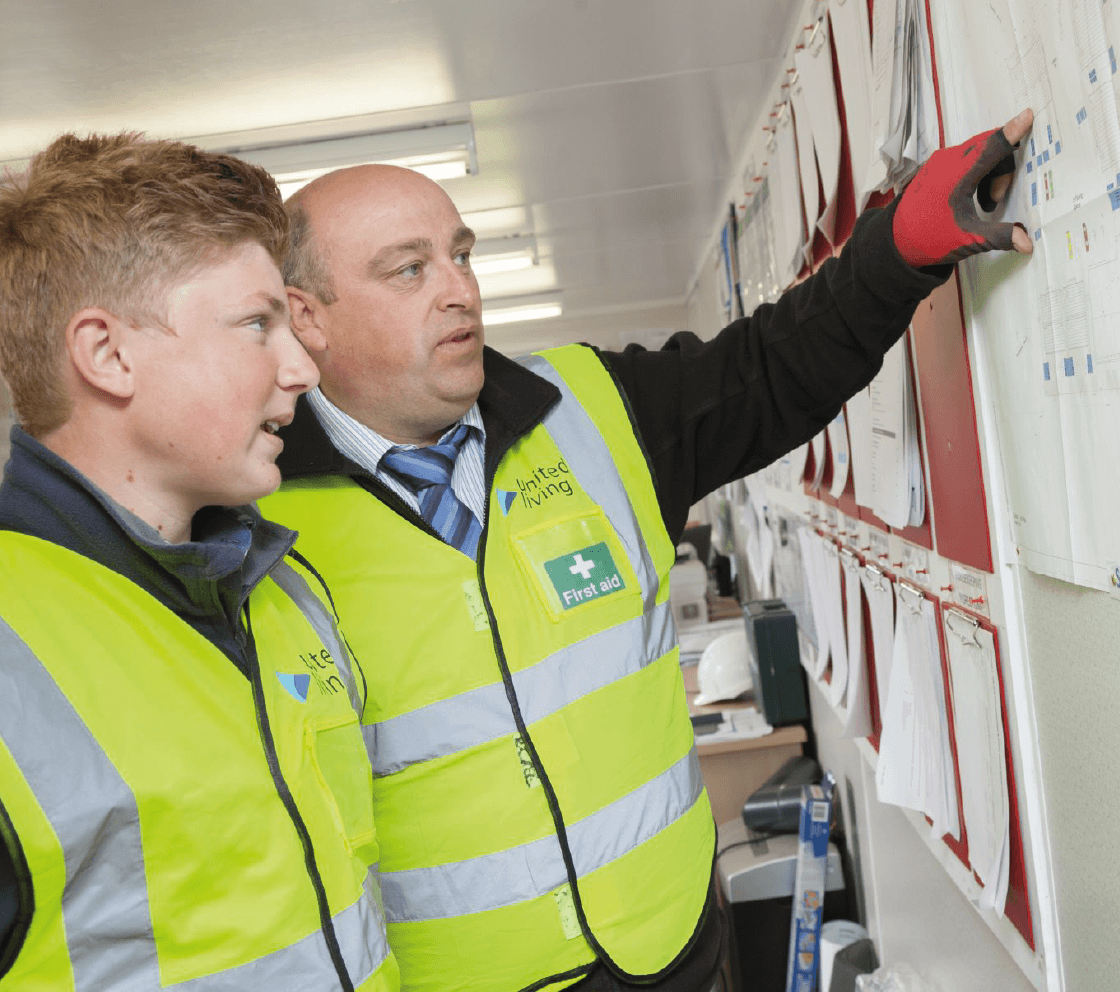 apprentice reviewing noticeboard with mentor